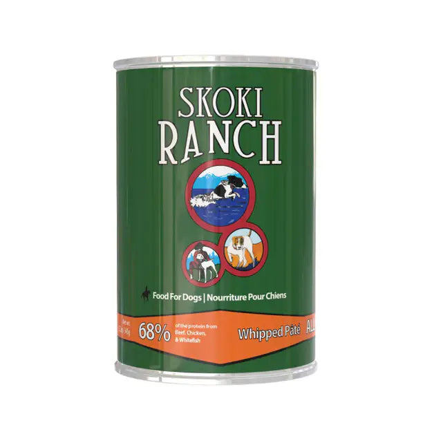 A can of Skoki Ranch Whipped Pork dog food on a plain white background. The can is dark green with white text and an orange band at the bottom, featuring circular illustrations of a dog, a cat, and a dog on leash at Harmony Pet Supplies, Scarborough.
