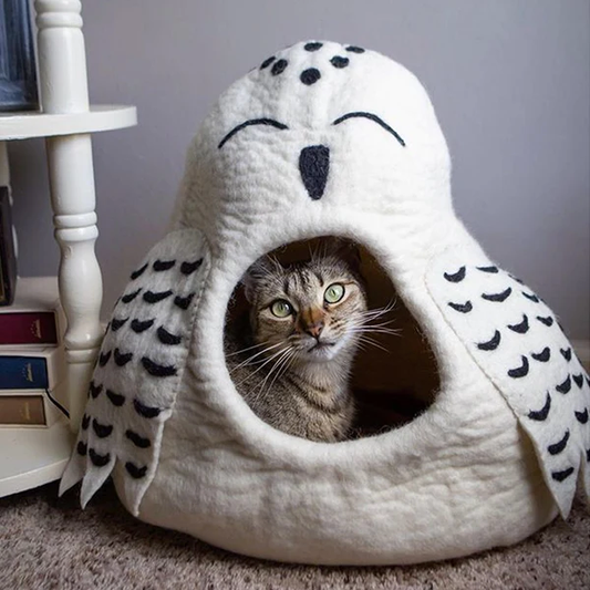Cat peeking out from a white pet bed shaped like an owl