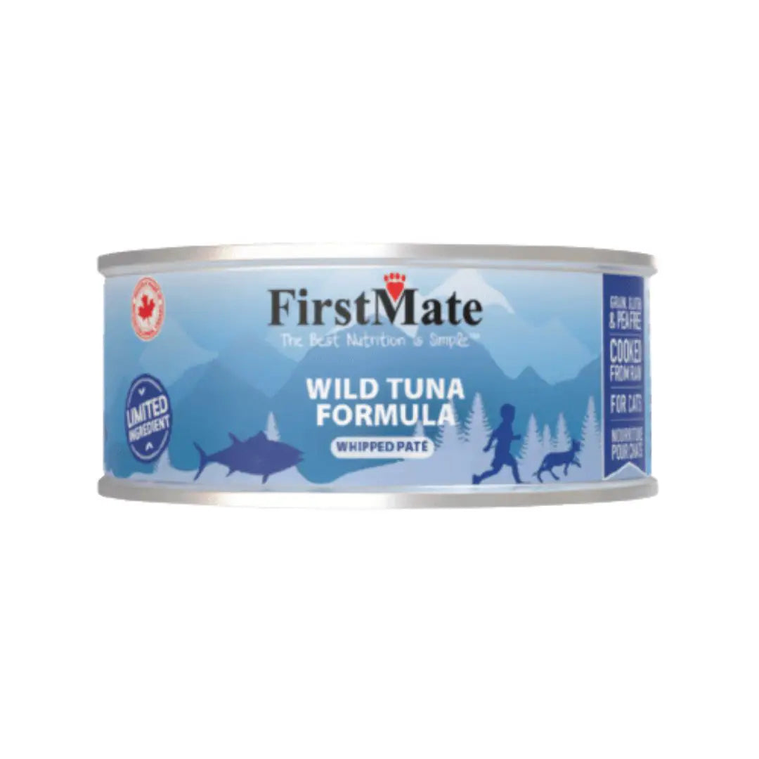 A can of FirstMate Wild Tuna Formula wet cat food, featuring a light blue label with dark blue mountain silhouettes, a shark, and a dog silhouette, on a plain white background at Harmony Pet Supplies, Scarborough