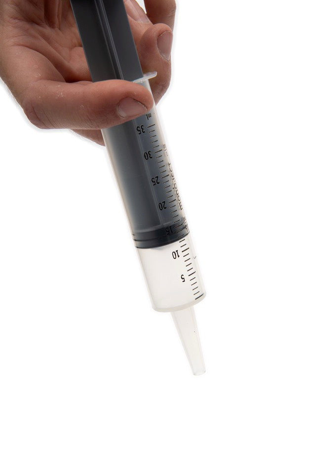 Hand holding a syringe with a white background