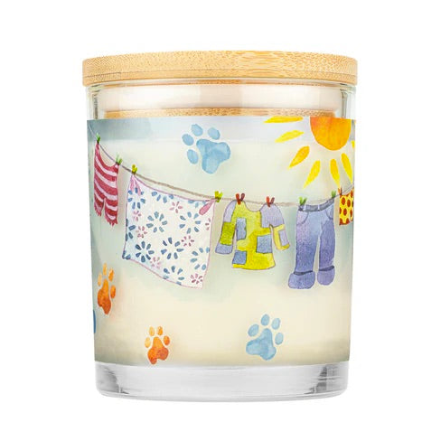 Candle with a wooden lid featuring a design of clothes drying on a line with a sun and paw prints.