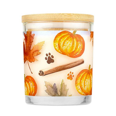 Candle with pumpkin, leaf, and cinnamon design on a white background