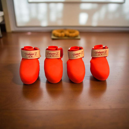 Four red pet boots with 'Petgen Z' branding on a wooden floor.
