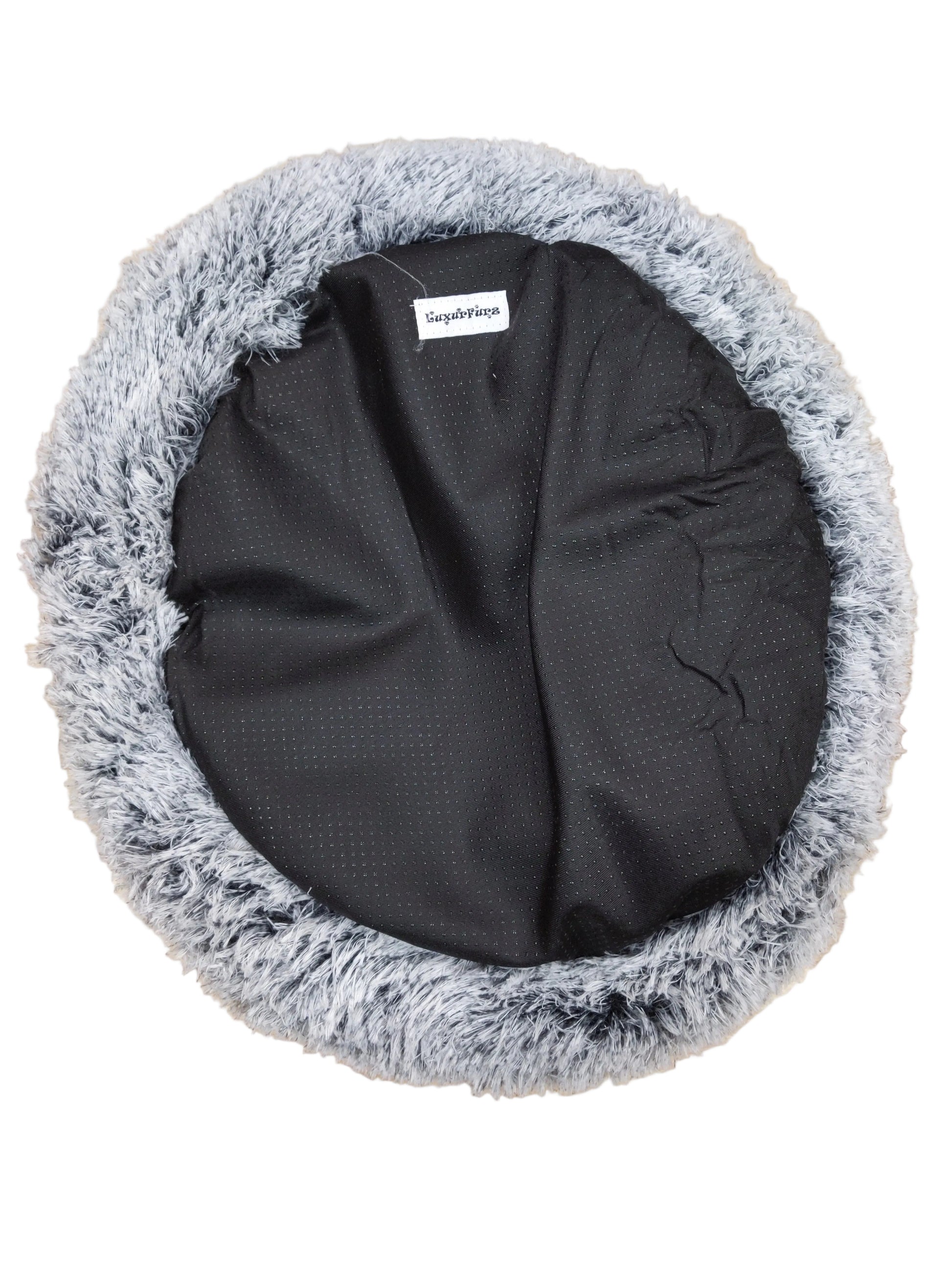 LuxurFurz Round pet bed with gray fluffy rim and black exterior base with firm grip on a wooden floor at Harmony Pet Supplies scarborough 